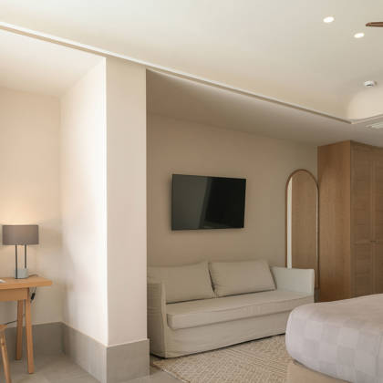 Intérieur de Suite Junior avec canapé, télévision à écran plat, bureau en bois et armoire encastrée