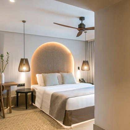 Chambre Deluxe avec lit double, tête de lit arquée, bureau en bois et étagères avec serviettes