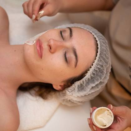 Cliente recevant un soin du visage avec application de crème