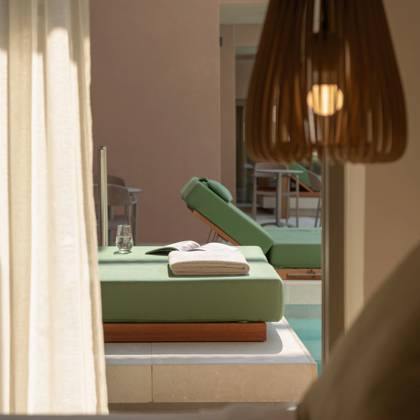 Lit de repos avec serviettes au bord de la piscine Swim Up, vu depuis l'intérieur de la suite
