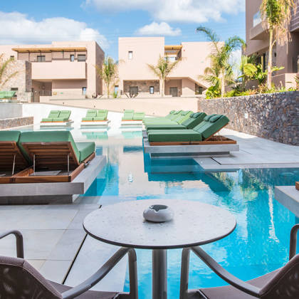 Terrasse de suite Swim Up avec table, chaises, lits de repos et accès direct à la piscine
