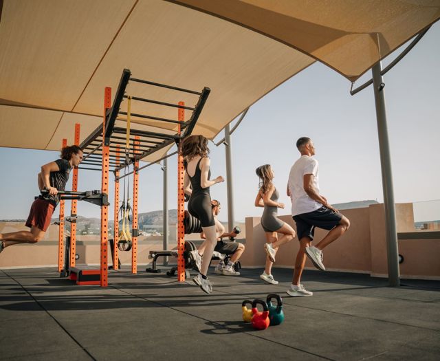 Gruppentraining im Open-Air-Gym, Gäste trainieren unter den Sonnensegeln