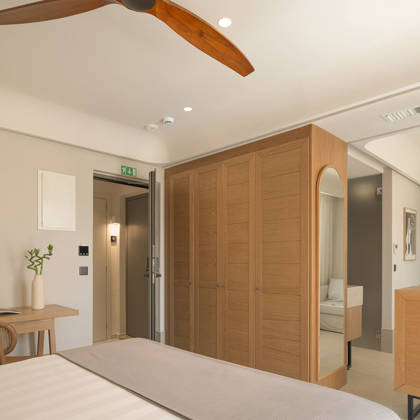 Intérieur de Suite Junior avec armoire en bois, bureau, télévision et ventilateur de plafond