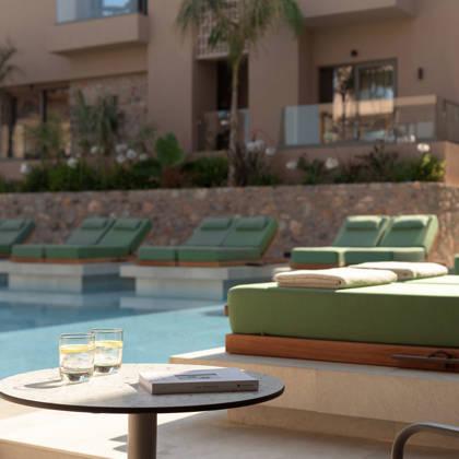 Terrasse Swim Up avec lits de repos et table avec boissons au bord de la piscine des suites