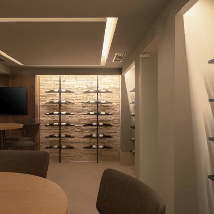 Salle de cave à vin avec casiers, tables rondes et écran pour les dégustations