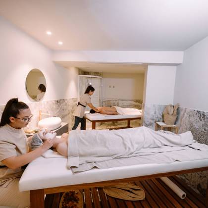 Salle de soins avec deux thérapeutes s'occupant de clients sur les tables