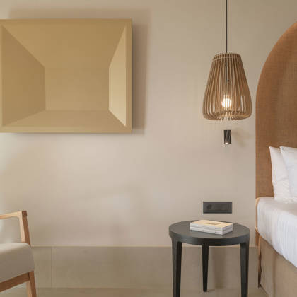 Détail de Suite Junior avec suspension tressée, table de chevet, fauteuil et œuvre d'art au mur