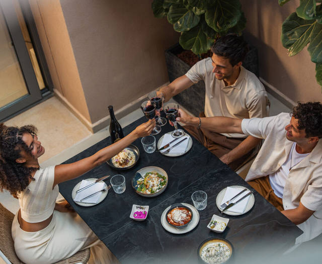 Three guests toasting with red wine over an à la carte dinner at the restaurant