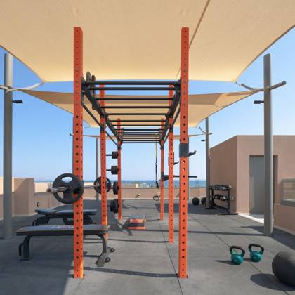 Station de musculation sur le toit avec banc, kettlebells et poids sous voiles d'ombrage