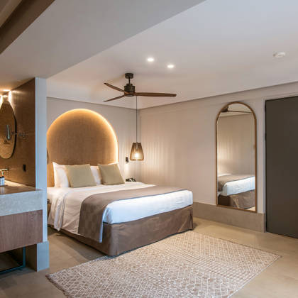 Suite Junior avec lit double, tête de lit arquée, vasque ouverte et grand miroir