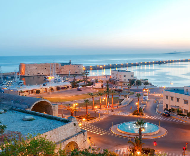 The Venetian fortress of Koules and the harbour of Heraklion lit up at dusk