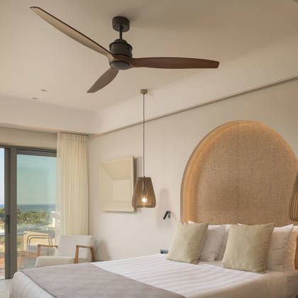 Suite Junior avec lit double, tête de lit arquée et porte-fenêtre ouvrant sur la vue mer
