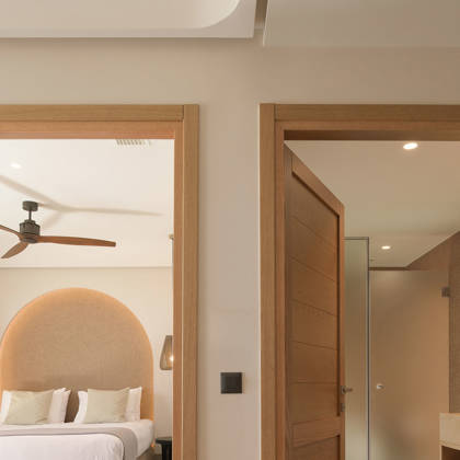 Suite avec chambre séparée à tête de lit arquée et porte menant à la salle de bain