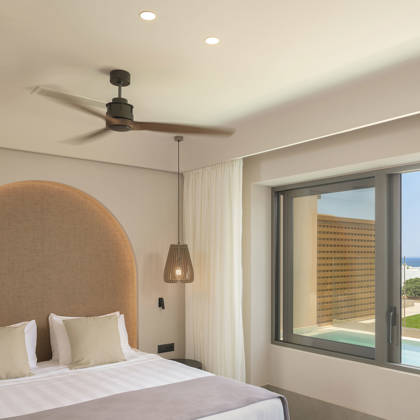 Chambre de la suite avec tête de lit arquée et fenêtre donnant sur la piscine et la mer