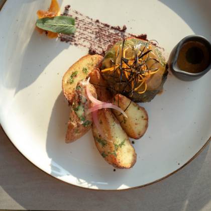 Assiette à la carte de poisson, pommes de terre rôties, herbes et sauce à part