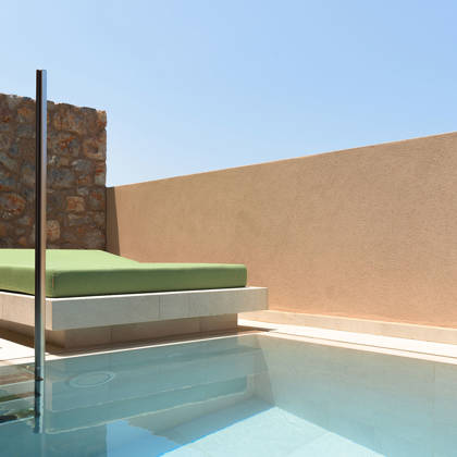 Piscine privée de la suite avec lit de repos et table d'appoint sur la terrasse ensoleillée
