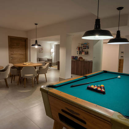 Le playroom avec billard, tables de jeux de société et suspensions chaleureuses