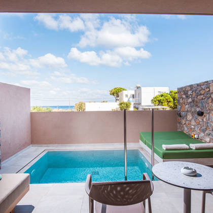 Terrasse de Suite Junior avec piscine privée, lit de repos, canapé et table, avec vue sur la mer