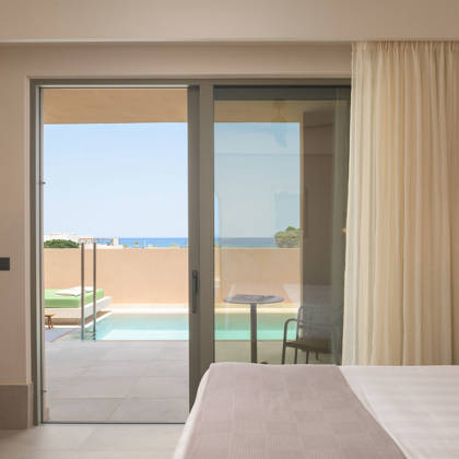Chambre de la suite ouvrant sur la terrasse avec piscine privée et vue dégagée sur la mer