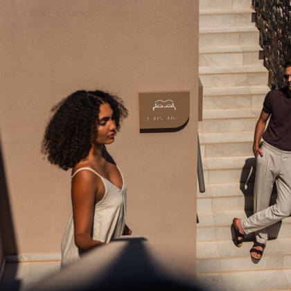 Un couple dans l'escalier ensoleillé près du mur en pierre et de la signalétique